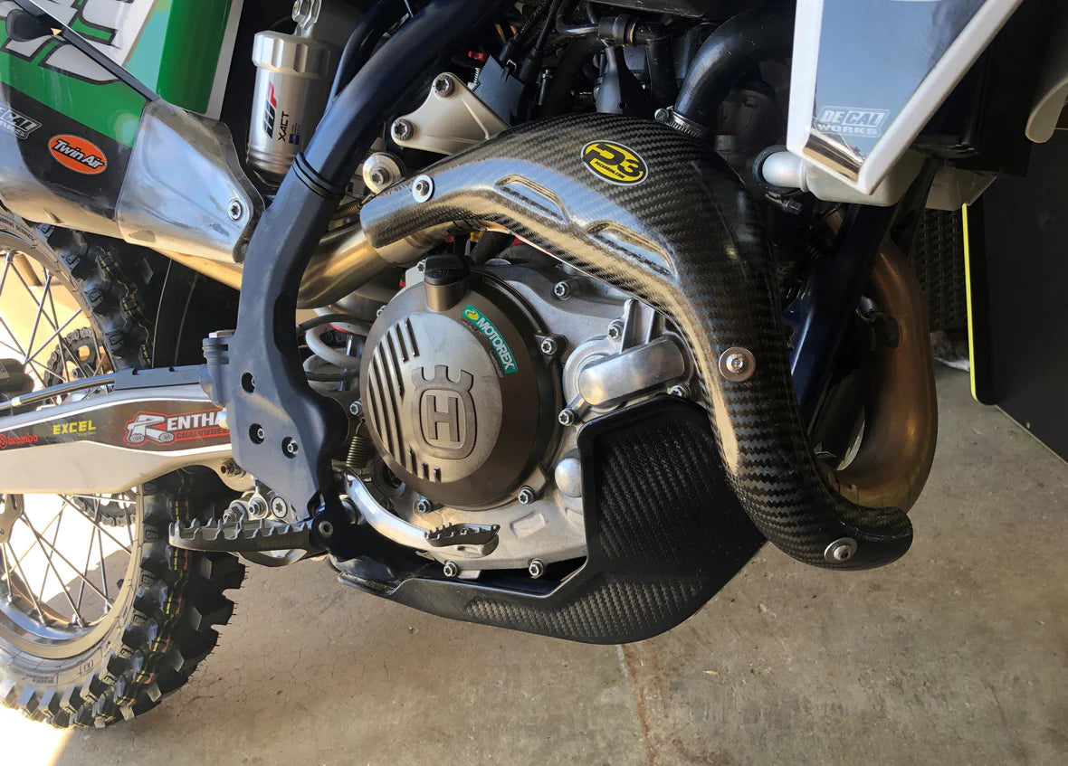 Close-up of a motorcycle engine with visible Husqvarna branding on a concrete floor.