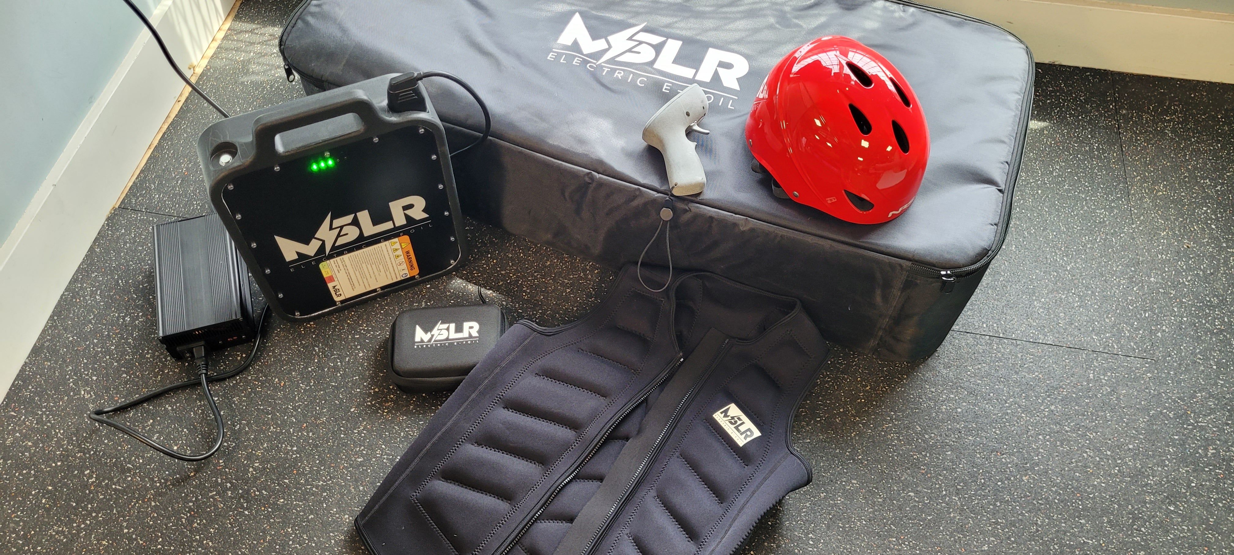 MSLR equipment including a helmet, bag, and foot pedals on a floor.