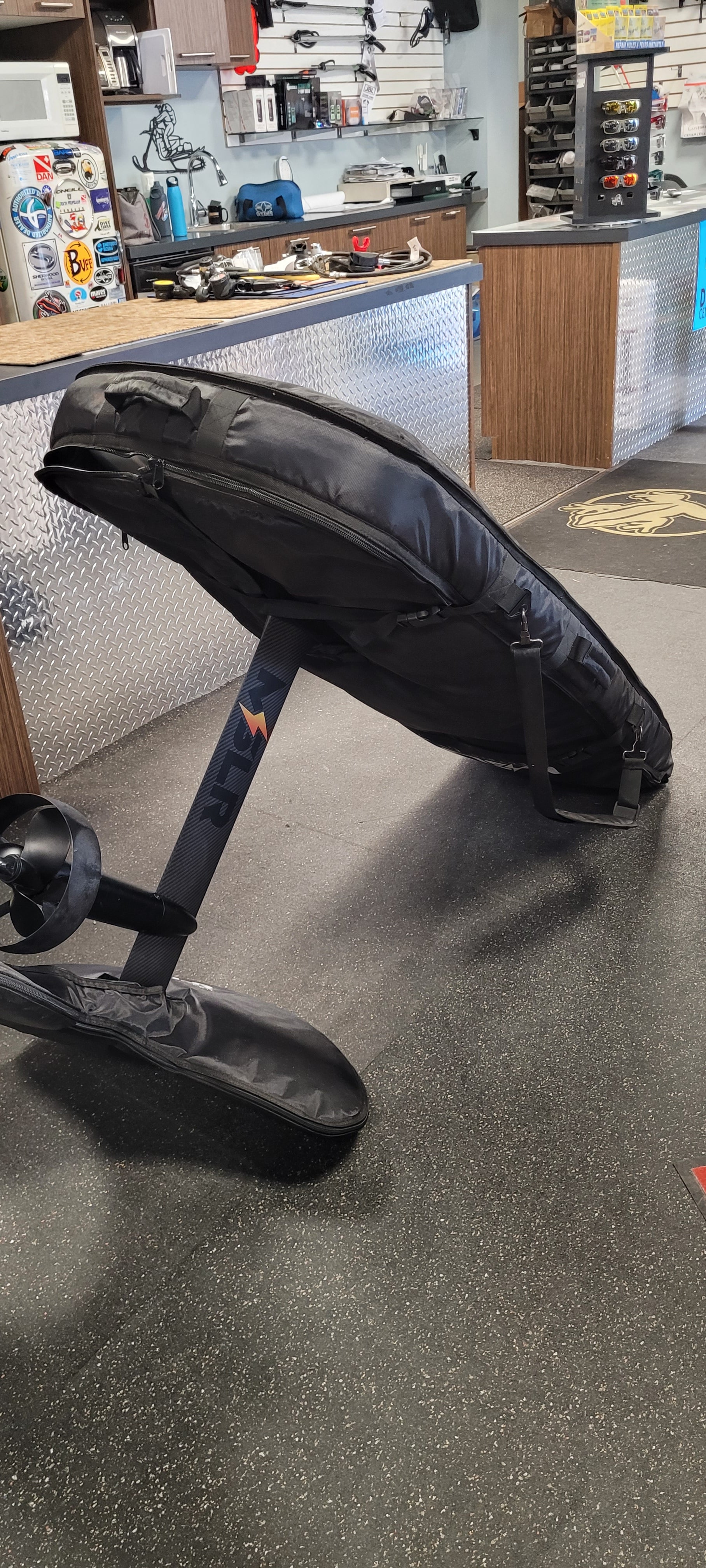 Black gaming chair in a store setting with shelves and products in the background