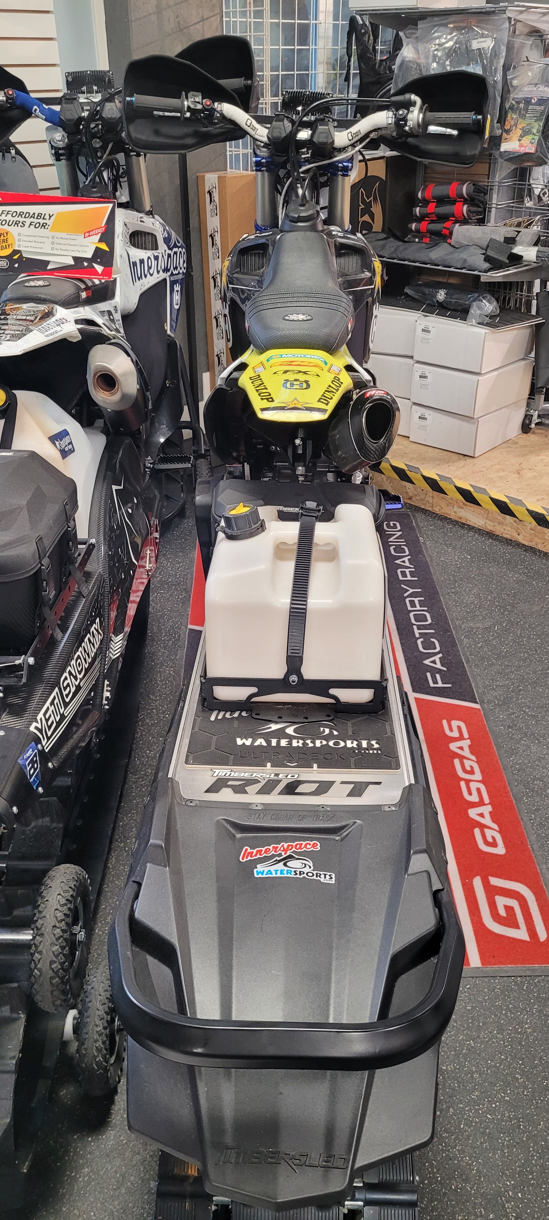 Close-up of a GoPro camera setup on a GoPro branded stand with various equipment in the background.