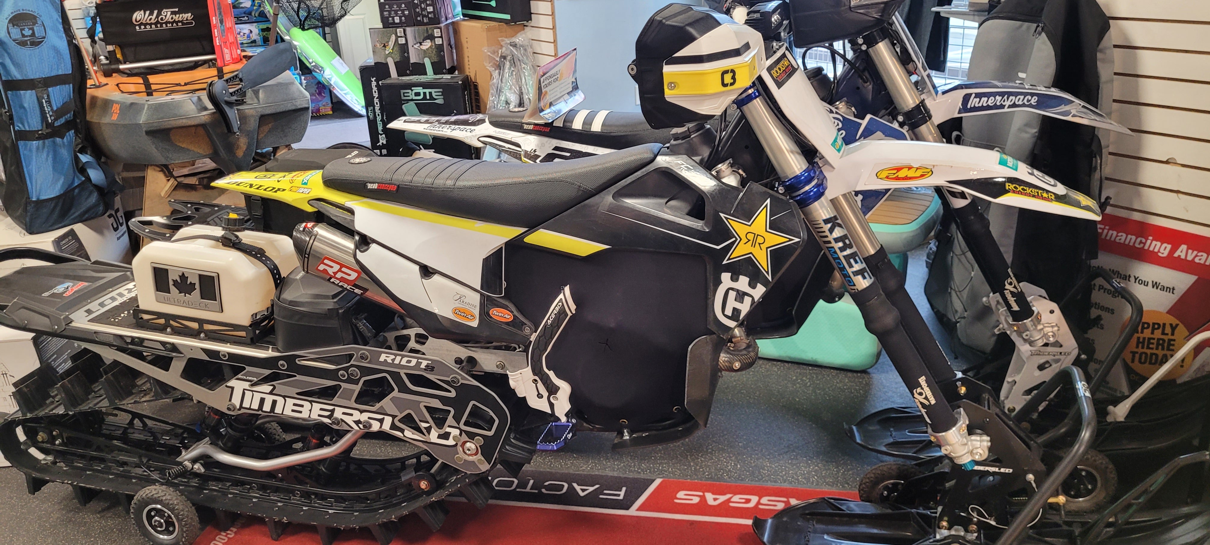 Model snowmobile on display with various items in the background