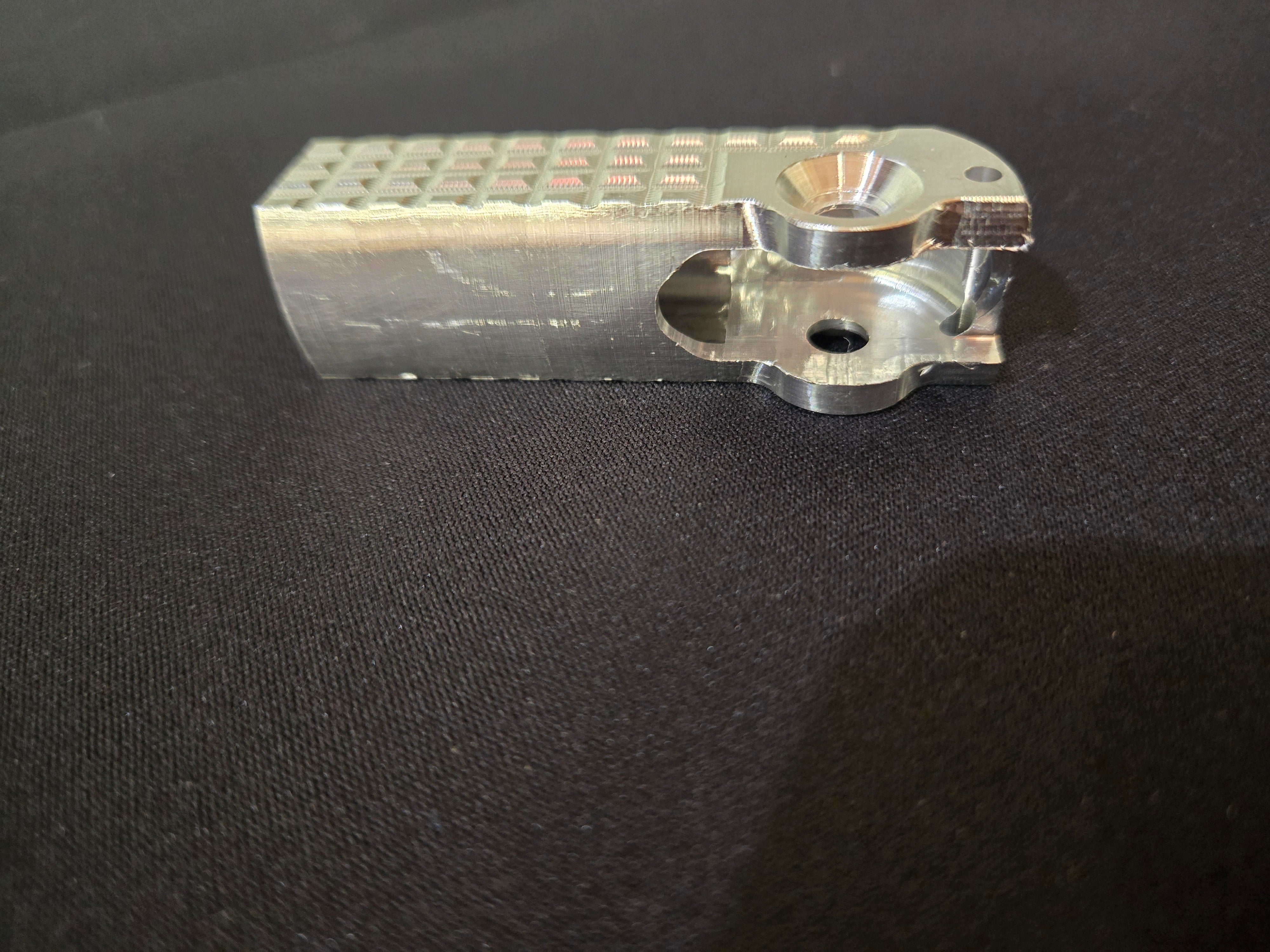 Metallic object with text and cutouts on a black background