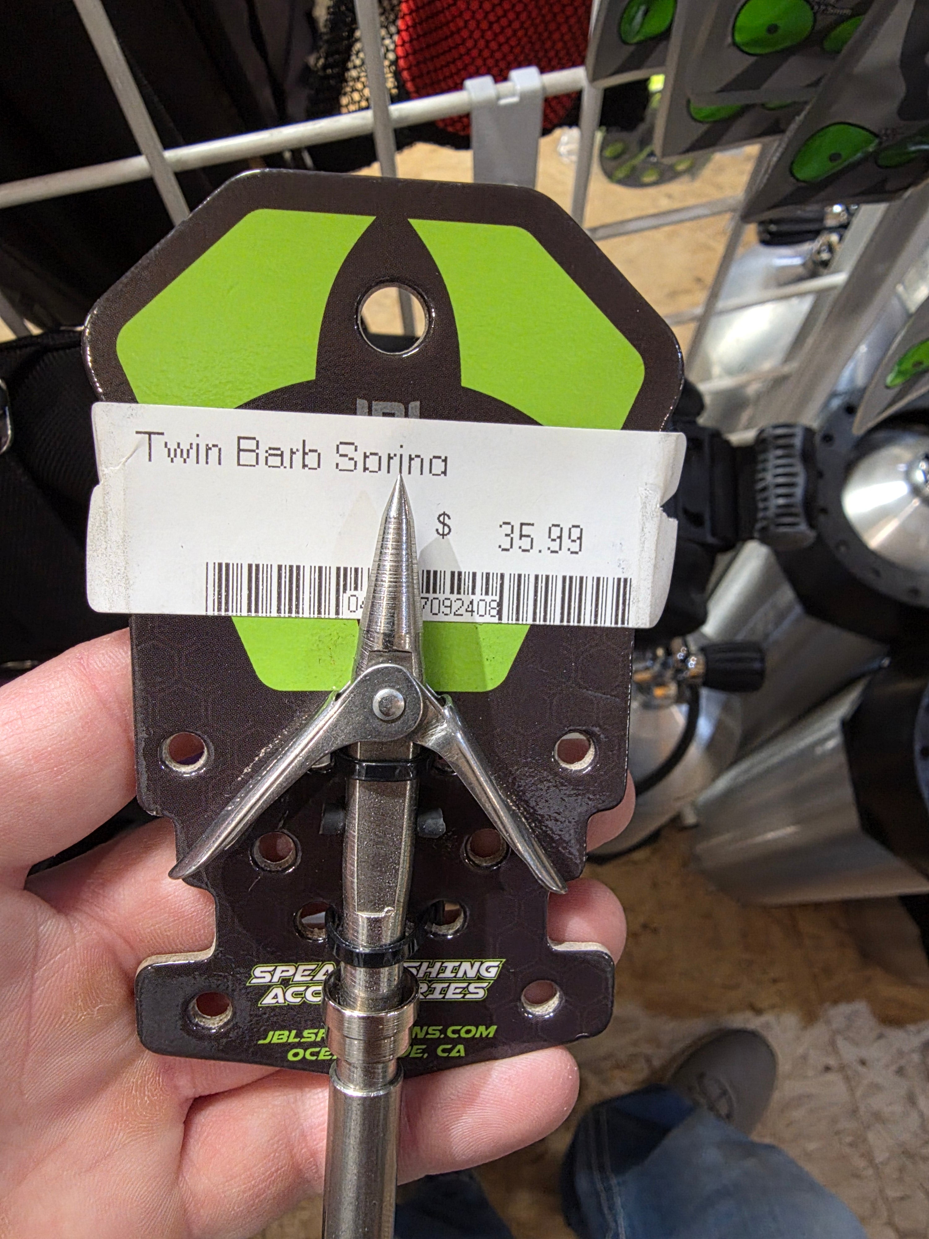 Hand holding a fishing tool with a price tag on it, blurred background