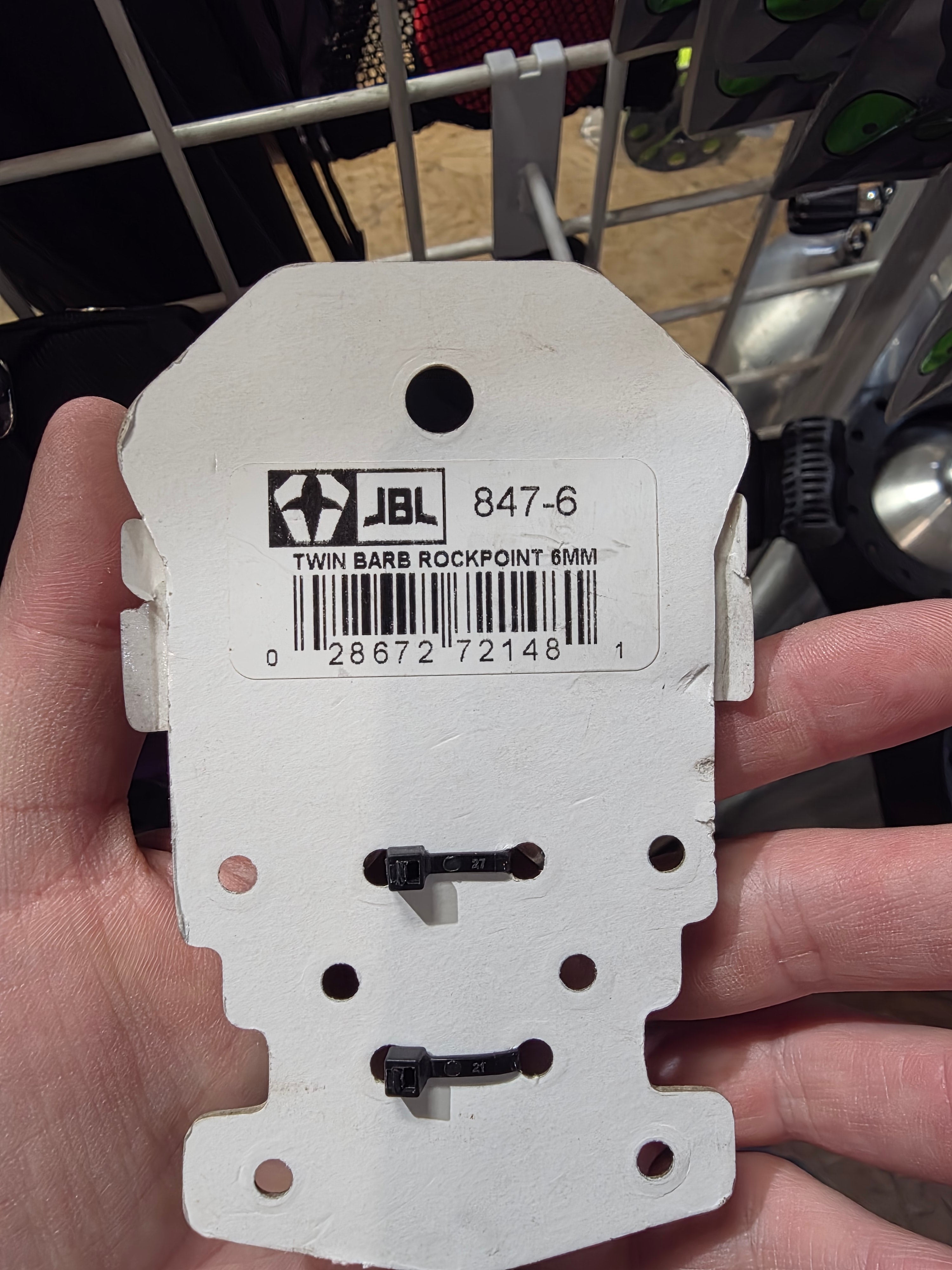 White plastic component with barcode and JEL logo held by a hand