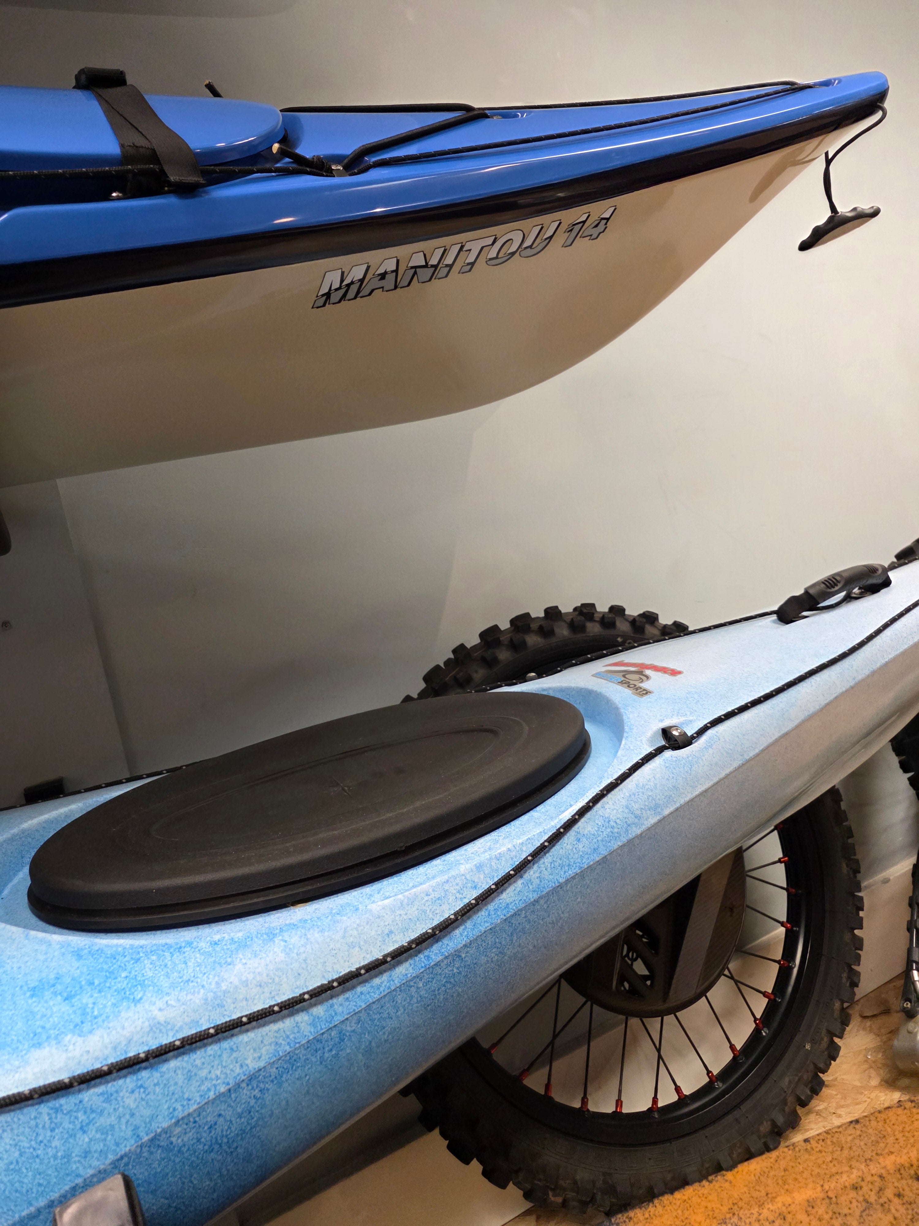 Blue and white electric bike with a large black wheel inside a garage.