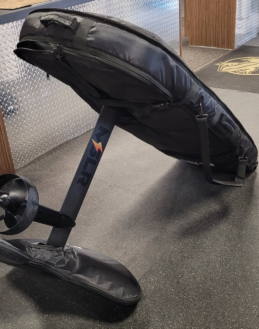 Black baby stroller with a visible brand logo on a textured floor.