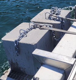 Concrete blocks with chains attached to a dock by a body of water