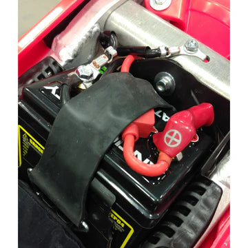 Close-up of a battery and wiring harness in a vehicle's engine compartment.