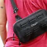 Person holding a black bag with visible branding