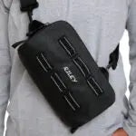 Black bag with multiple compartments on a person's shoulder