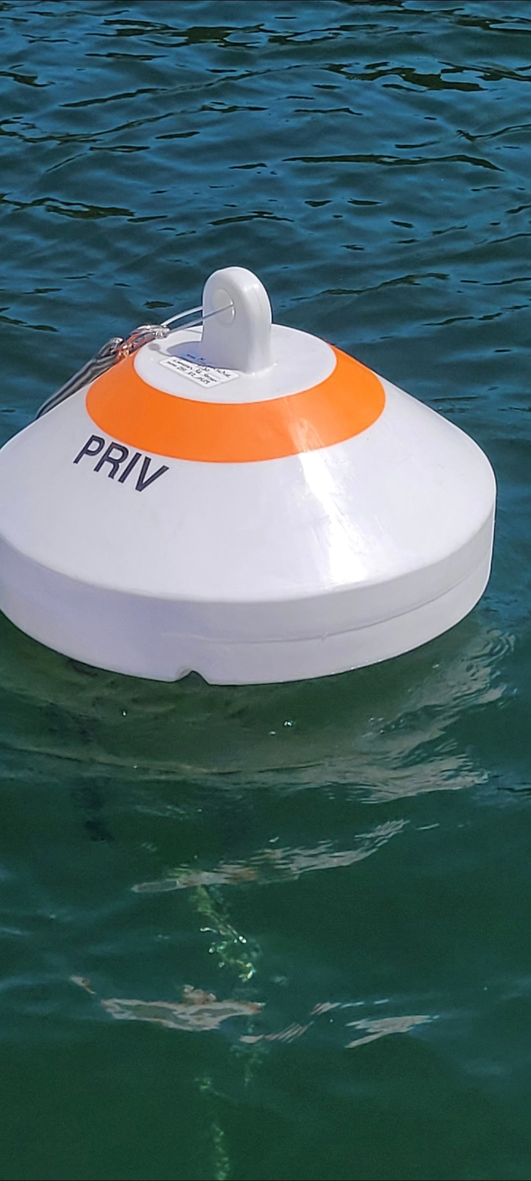 Floating device with an orange circle and 'PRIV' text on a body of water