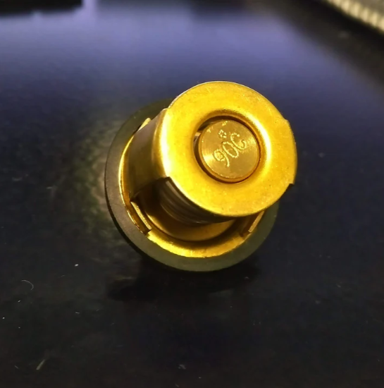 Gold-colored mechanical component on a dark surface