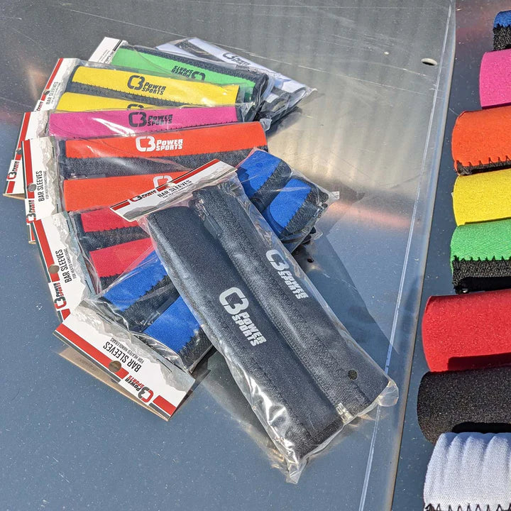 Colorful barbell sleeves in packaging on a reflective surface