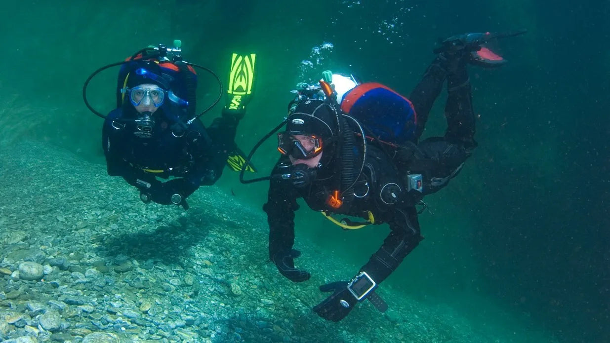 Two scuba divers underwater with diving equipment