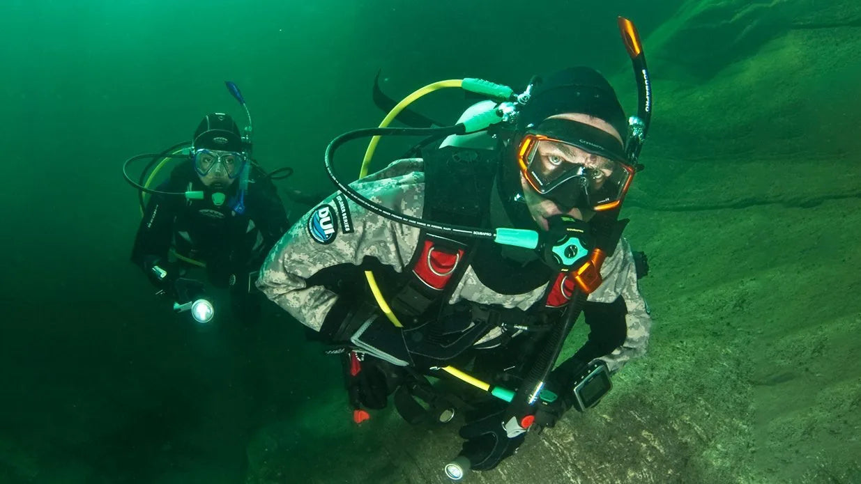 Two scuba divers underwater with diving equipment