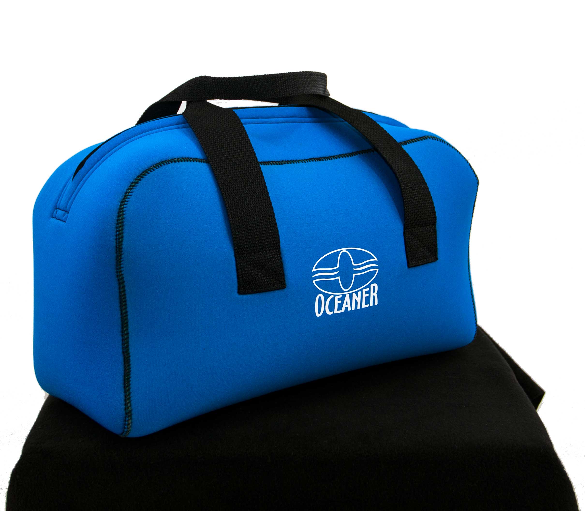Blue duffel bag with black handles on a black surface