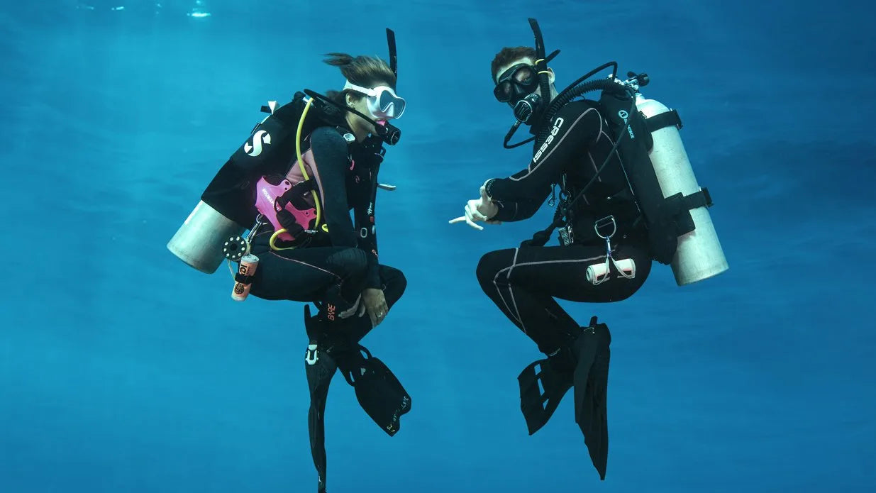 Two scuba divers underwater in a clear blue ocean