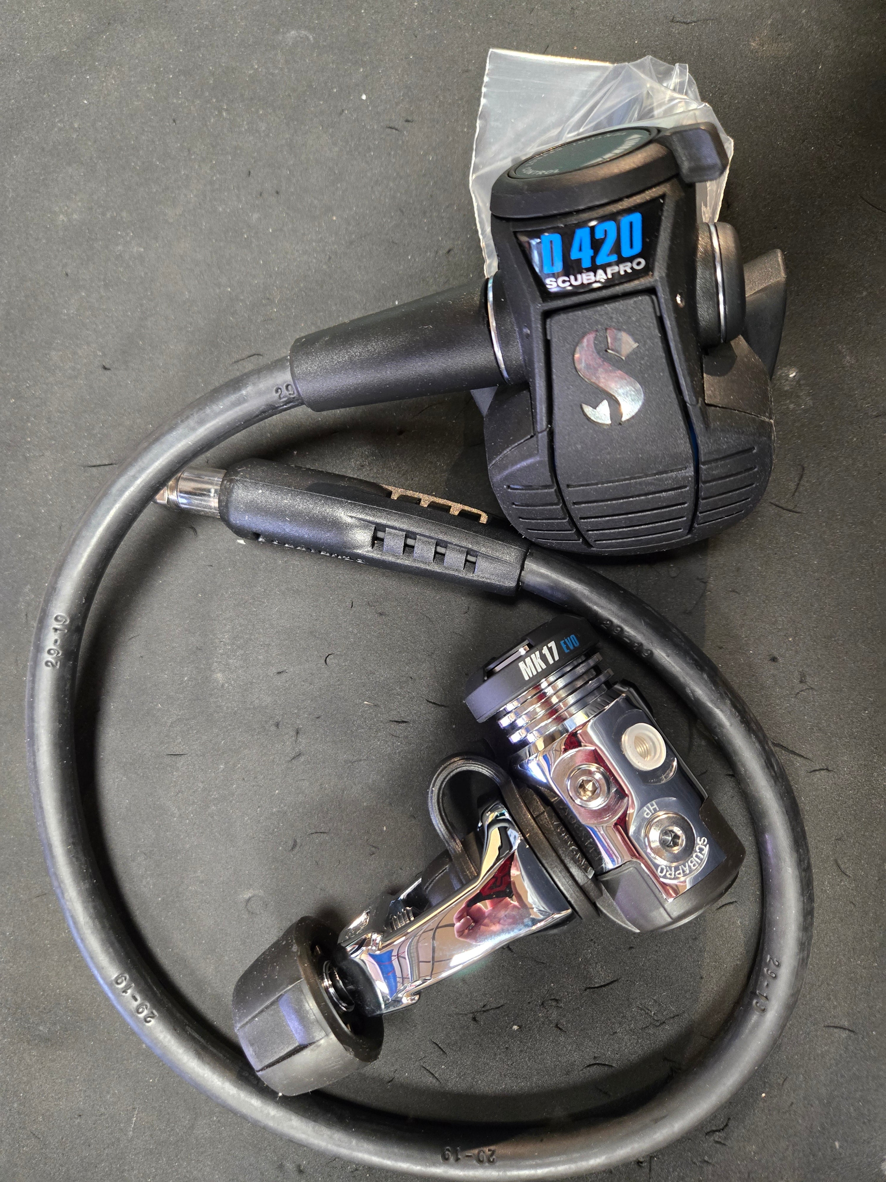 Two bicycle shifters with a cable on a dark surface