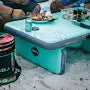 People sitting around a teal dining table outdoors