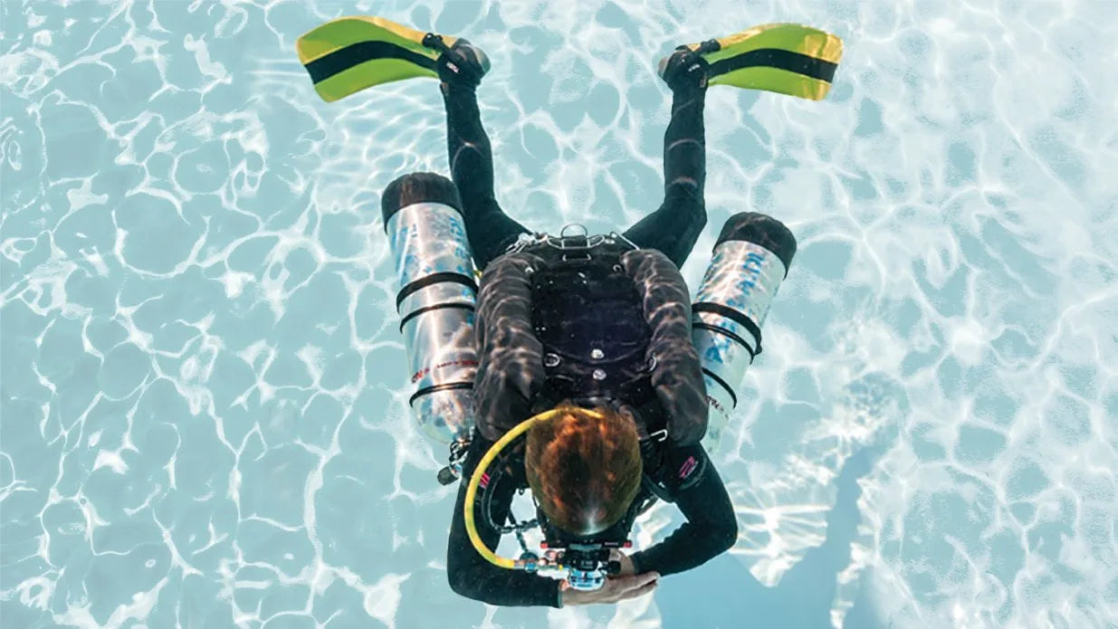 Person underwater in clear blue water wearing scuba gear